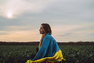 Woman with a Ukranian flag wrapped around her.