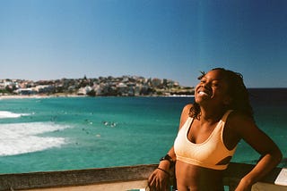 girl at the beach smiling towards the sun