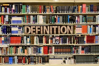 A bookshelf with books and the word definition — referring to the need to define the term innovation.