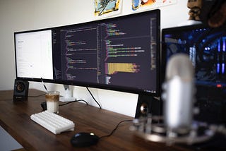 The workplace of a web developer, big monitors with code on a table