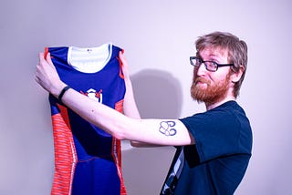 The author David Barrett holding up the dress.