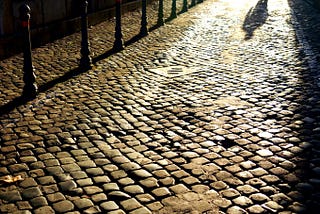 Man walking on cobblestone street