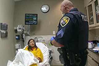 Police talking to a woman in a hospital bed