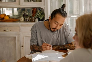 A dad studying and learning with daughter at a table.