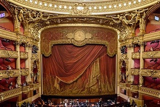 View of gilded, red-curtained stage.