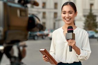 A journalist talking to a camera.