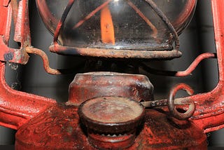 an antique gas lamp flickers with a tiny flame
