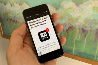 Phone in hand that shows a message saying that the phone app is out of date and needs updating.