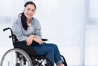 A disabled woman sitting on a wheelchair while wearing a headphone