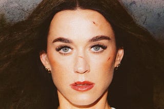 Taken from the cover art of Katy Perry’s latest single, “Bandaids.” In the image, her face is covered in scars, and she looks tired yet defiant.