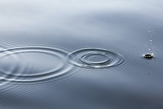 The image of three ripples on a still lake forming concentric circles