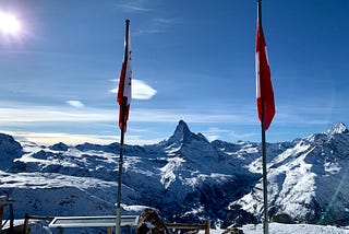 The Matterhorn in between a Valais canton flag and a Swiss flag