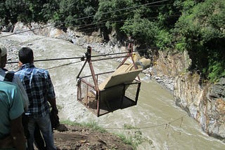 Disaster Response Team members and volunteers transporting relief materials (tents, black boards, stationery items) for a school damaged by a flood.