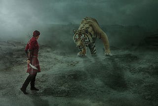 Man wielding a knife against a big tiger