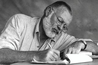 Ernest Hemingway writing by hand while on safari.