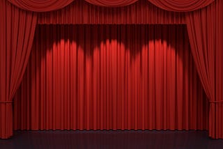 Red curtains framing an empty stage