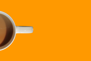 Mug of tea from above, set against an orange background