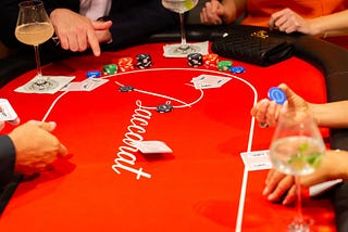 players around a baccarat table laying down their bets