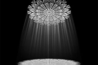 A circular stained glass window in the ceiling with light shining through it, forming a circle of light on the ground.