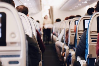 Flight attendant serving passengers on an airplane