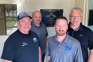 four men stand in an entryway