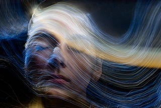 woman’s face with wavelike strands of light flowing over it from left to right