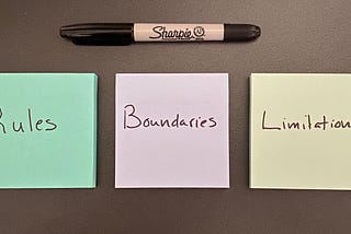 Three Post-it notes, each with one word: Rules, Boundaries, Limitations. Above them is a Sharpie marker.