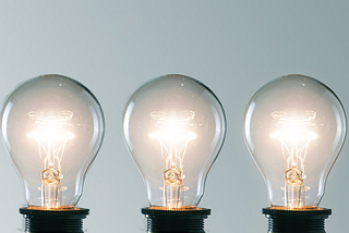 Image of four lit lightbulbs in an array of five.