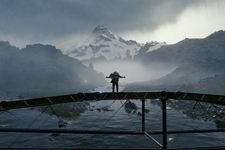 Death Stranding’s protagonist enjoying the scenery while standing on a bridge.