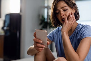 a woman looking at her smartphone with concern