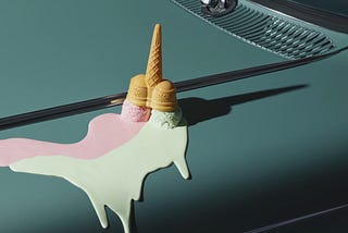 Ice cream upside down, melting on an engine hood.