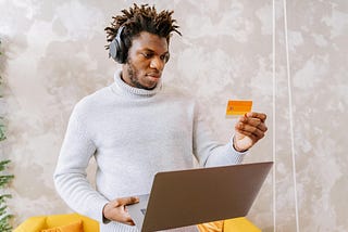 Man online shopping looking at his credit card.