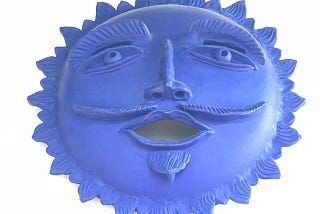 A ceramic blue sun with a face.
