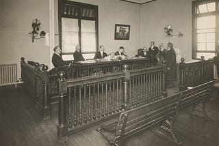 A bearded immigrant appearing before a board of inquiry, Ellis Island.
