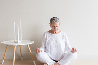 older woman sitting, meditating. Embracing Crone Wisdom: A New Chapter of Value and Insight