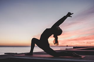 Woman stretching at sunset