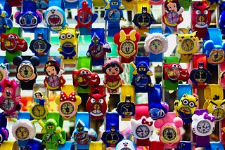 A display of colorful watches, each one being some cartoon or comic book character.