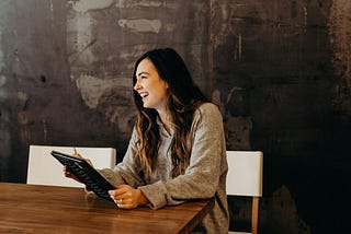 Woman with laptop smiling.