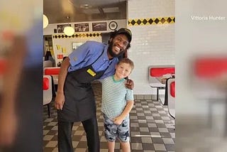 Man poses with boy smiling.