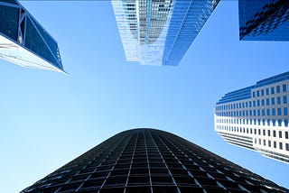 Photo of bright blue and cloudless sky with glass and concrete high-rise buildings framing the edges