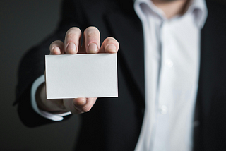 Man In Suit Holding A Blank Small Paper