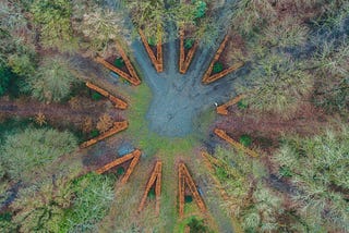 Photograph of several roads converging at one central point, surrounded by trees