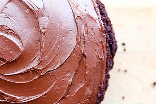 A rich chocolate cake with swirls of chocolate icing on top.