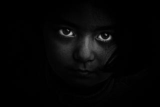 Child looking darkness all around, grayscale