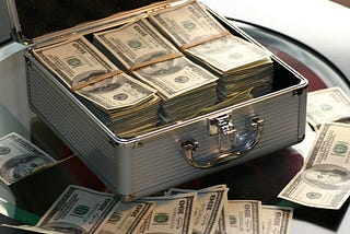 Chrome briefcase with several stacks of $100 bills.