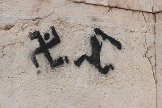 A graffiti that depicts a black and white shadow person persuing a caricatured swastika with a club