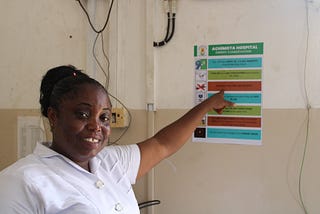 A woman pointing at a poster on a wall.