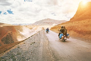 People driving on road on vespas.