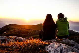 Close friends looking at horizon at sunset