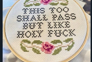 a piece of embroidery thats says “This Too Shall Pass But Like Holy Fuck”